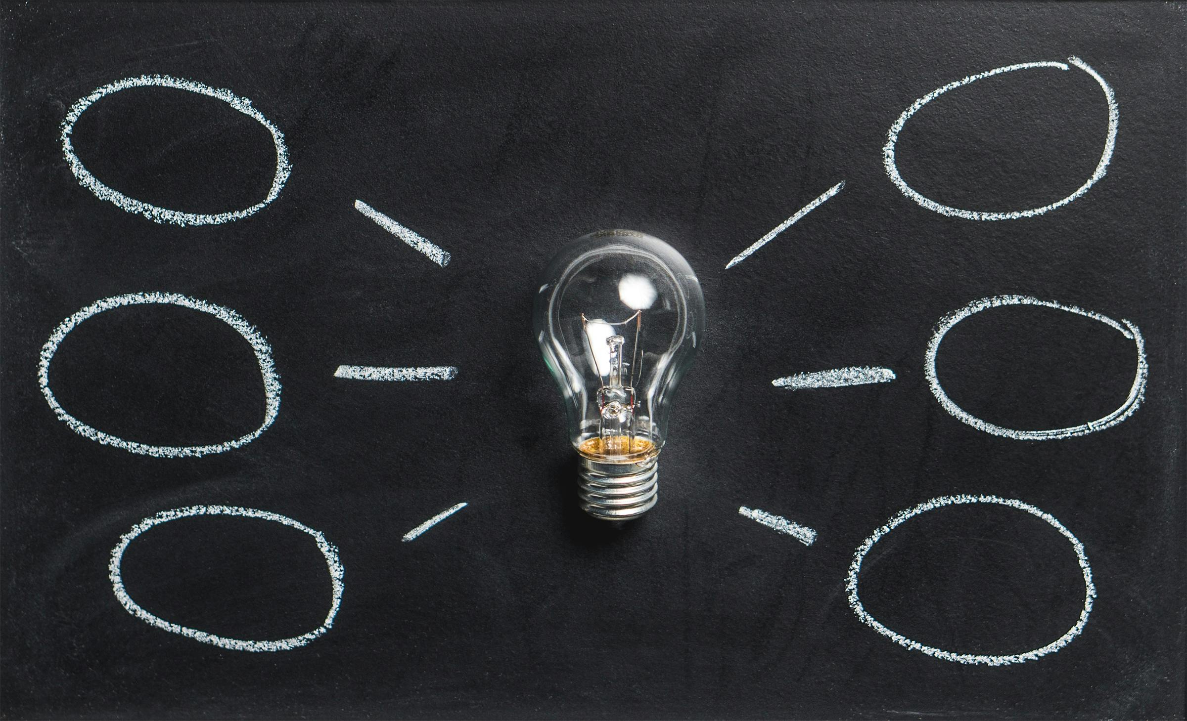 An abstract image of a light bulb with circles around it on a blackboard illustrating knowledge best practices